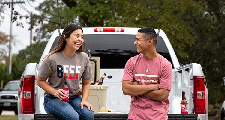 People wearing Beef merch sitting on truck bed